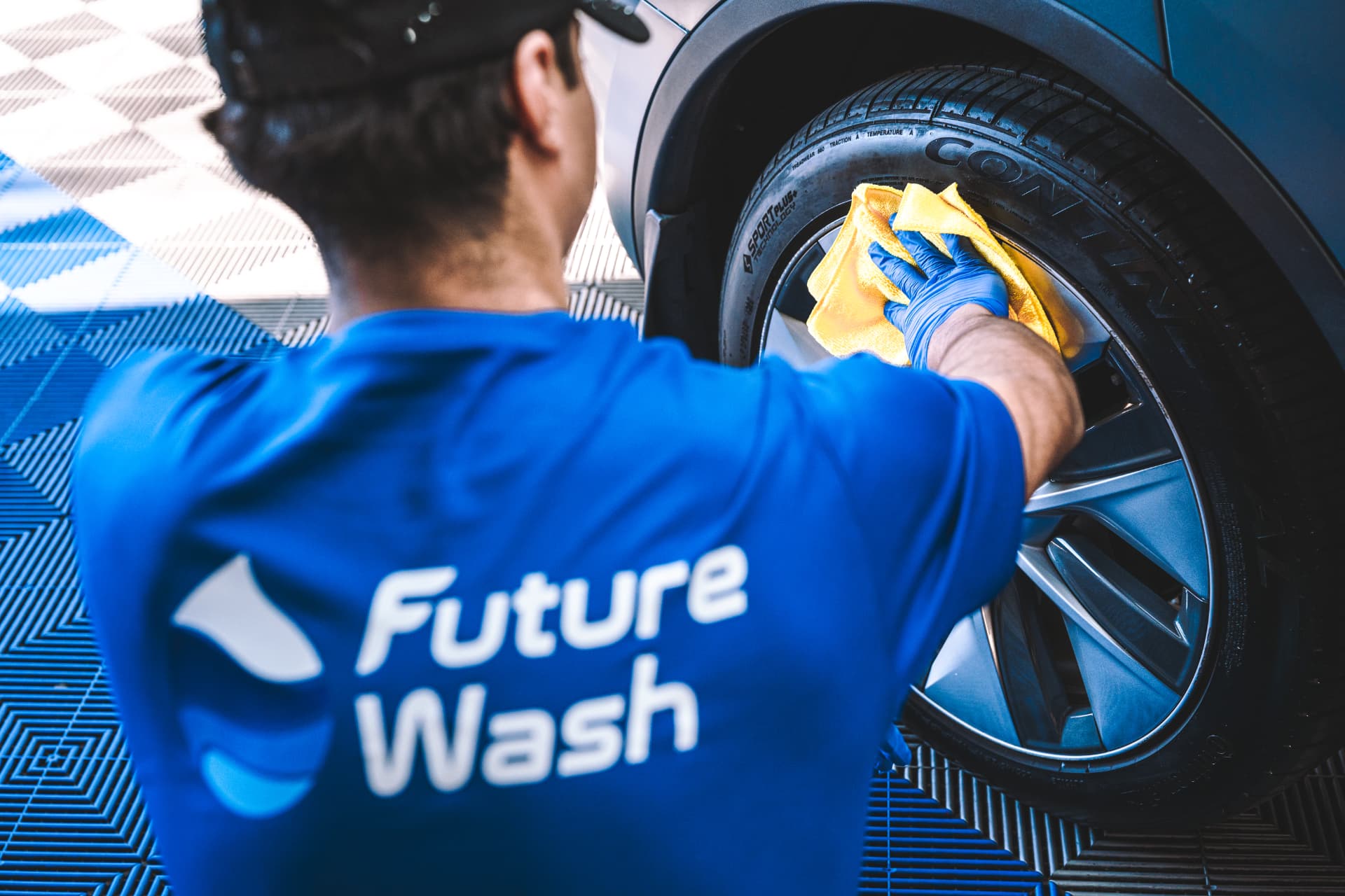 Future Wash technician wiping down a wheel with a microfiber towel