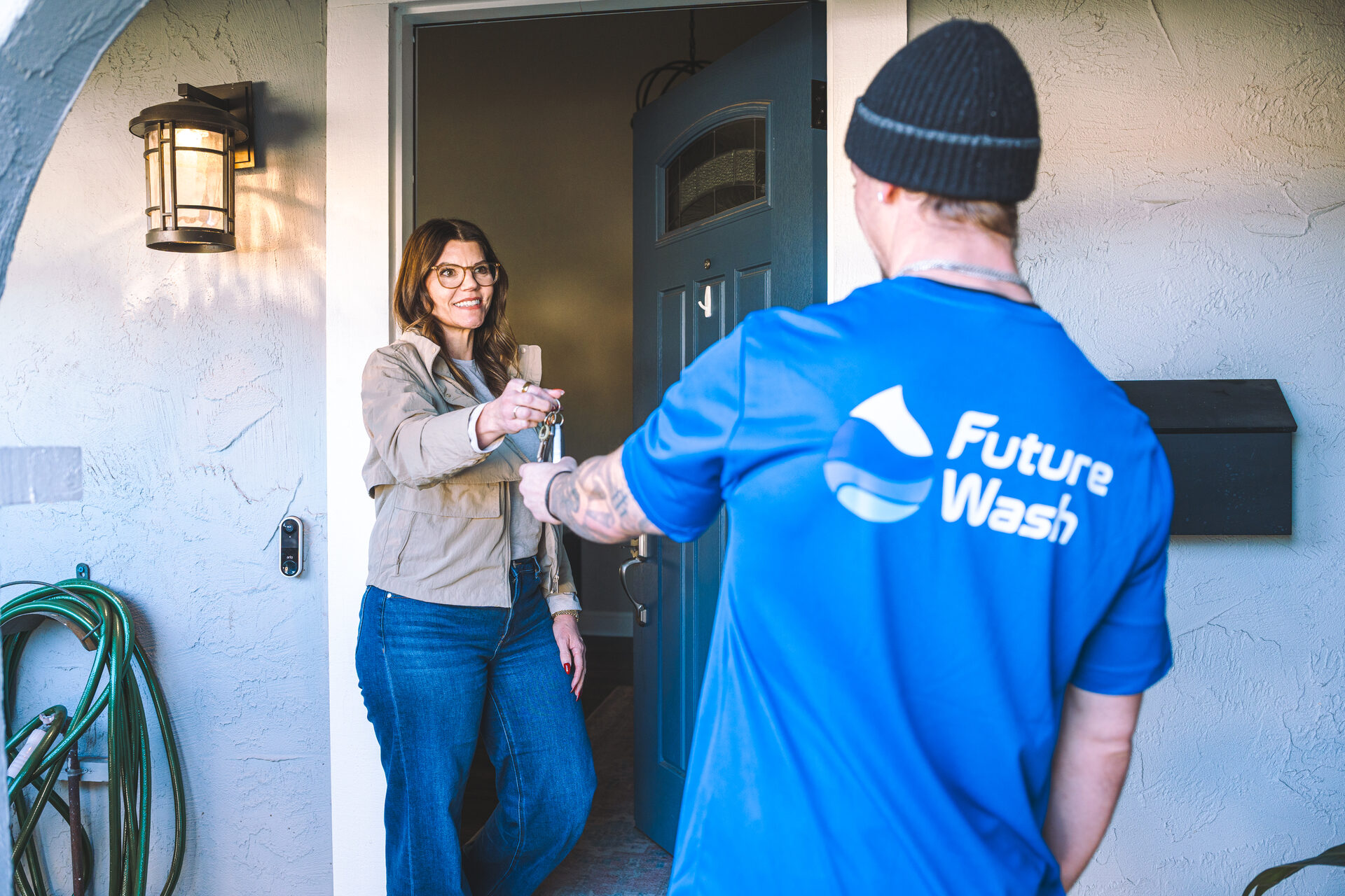 Customer handing car keys to a Future Wash technician at their front door