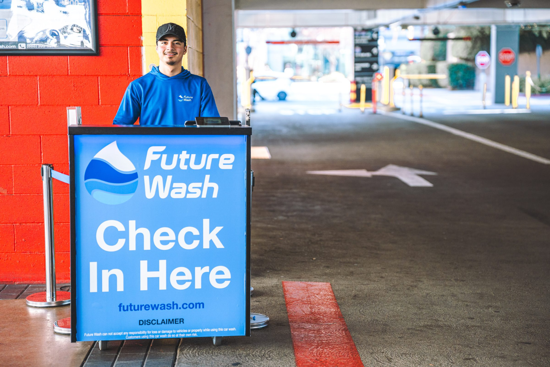 Future Wash technicians servicing vehicles in a covered airport parking structure