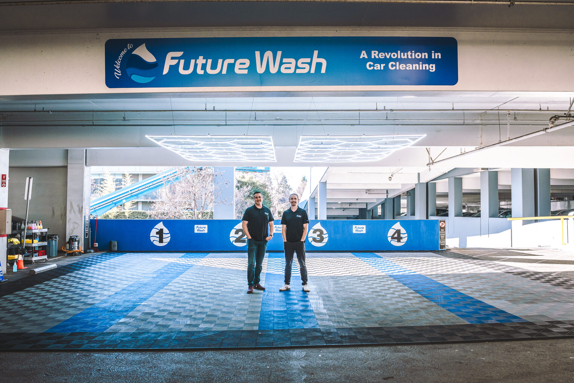 Future Wash founders standing inside their branded San Jose retail bay